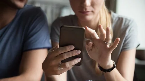 0_Couple-customers-holding-mobile-phone-using-smartphone-apps-close-up.jpg